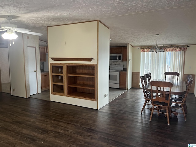 dining space with ceiling fan, dark wood-type flooring, and a textured ceiling