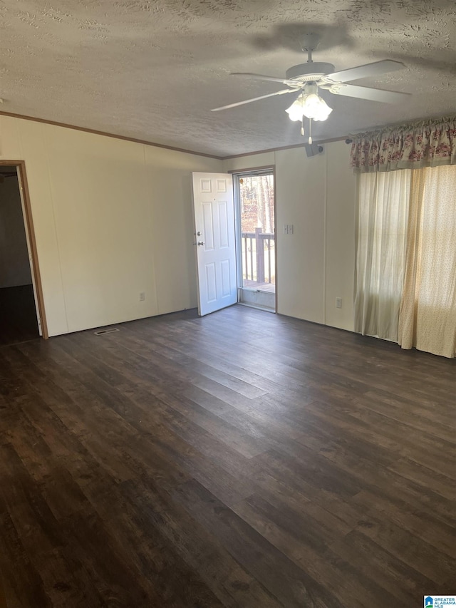 spare room featuring dark wood-type flooring, ceiling fan, and a textured ceiling