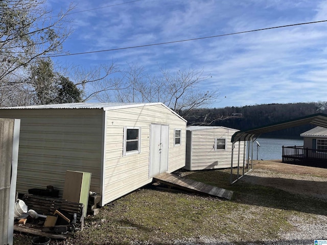 view of outbuilding featuring a water view and a carport