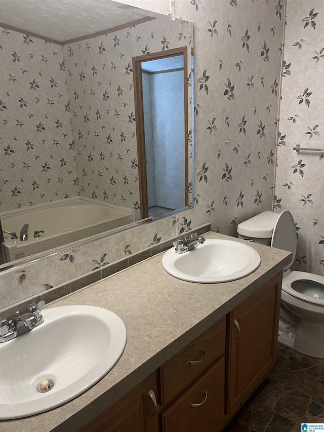 bathroom with crown molding, vanity, a textured ceiling, a tub, and toilet