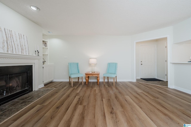 unfurnished room with a textured ceiling, dark hardwood / wood-style flooring, and built in shelves