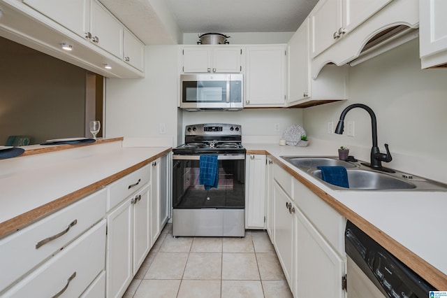 kitchen featuring white cabinetry, stainless steel appliances, sink, and light tile patterned floors