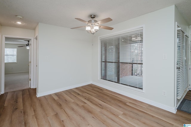 unfurnished room featuring ceiling fan, light hardwood / wood-style floors, and a textured ceiling