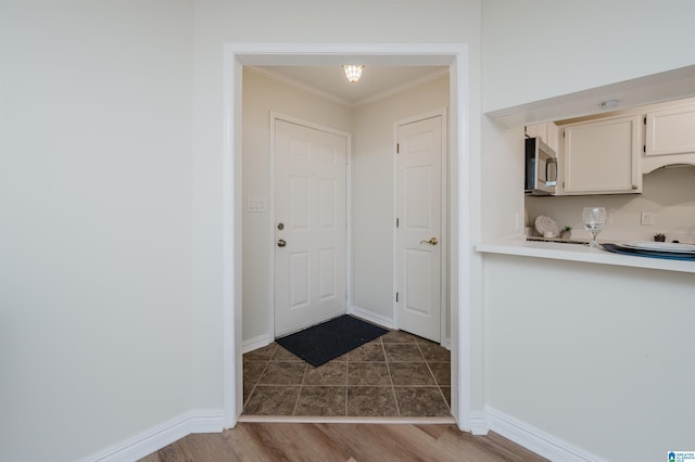 entryway with crown molding and dark wood-type flooring