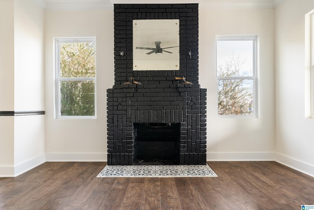 room details with a brick fireplace, wood-type flooring, ornamental molding, and ceiling fan