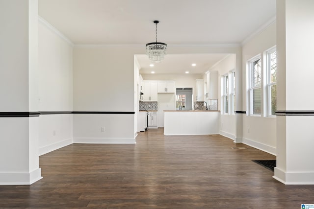 unfurnished living room with crown molding, dark hardwood / wood-style flooring, and a notable chandelier