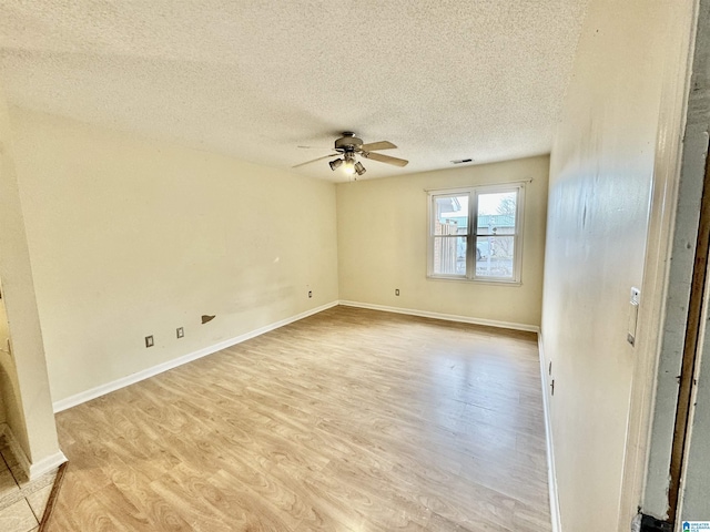 empty room with ceiling fan, a textured ceiling, and light wood-type flooring