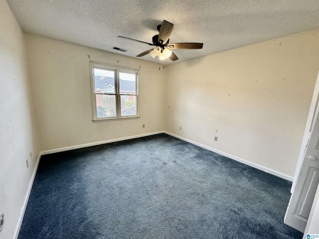 spare room featuring ceiling fan, a textured ceiling, and dark colored carpet