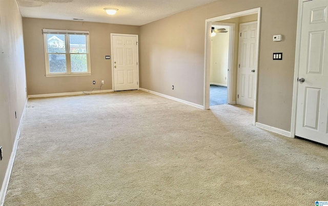 unfurnished room featuring light carpet and a textured ceiling