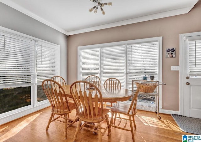 dining area with light hardwood / wood-style flooring and ornamental molding