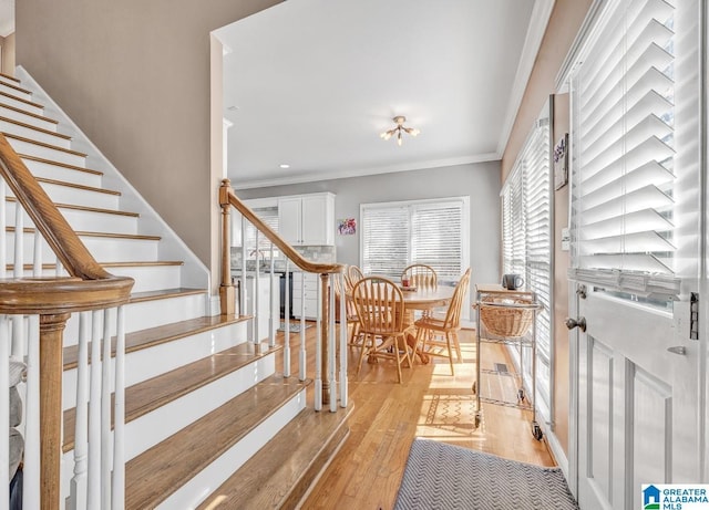 staircase with hardwood / wood-style flooring and ornamental molding