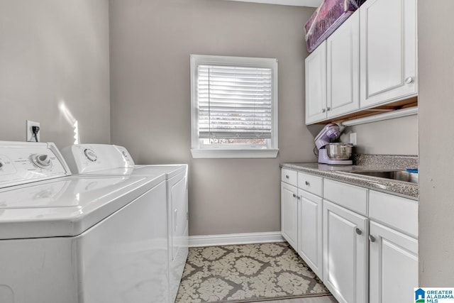 clothes washing area featuring cabinets, washer and clothes dryer, and sink