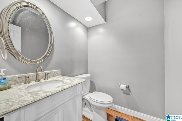 bathroom featuring vanity, wood-type flooring, and toilet