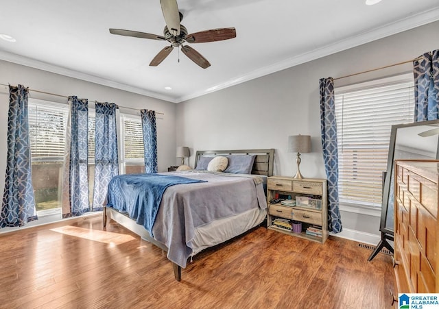 bedroom with wood-type flooring, ornamental molding, and ceiling fan