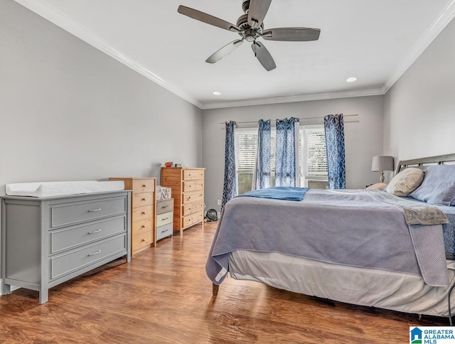 bedroom featuring ornamental molding, ceiling fan, and light wood-type flooring