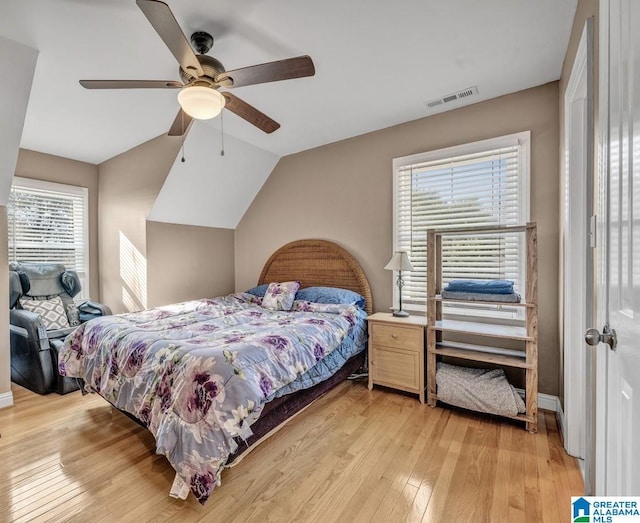 bedroom with ceiling fan, lofted ceiling, and light hardwood / wood-style floors