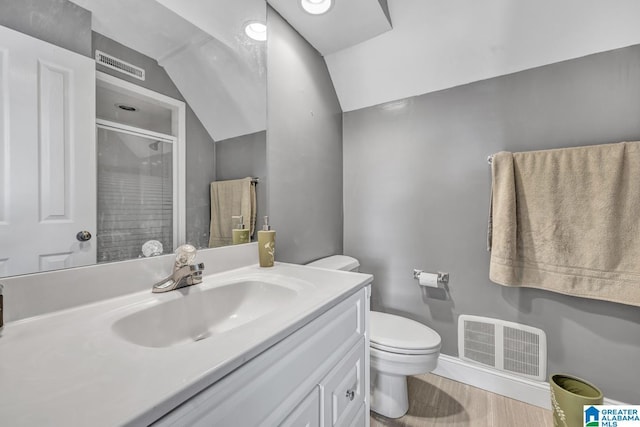 bathroom with a shower with shower door, wood-type flooring, lofted ceiling, vanity, and toilet