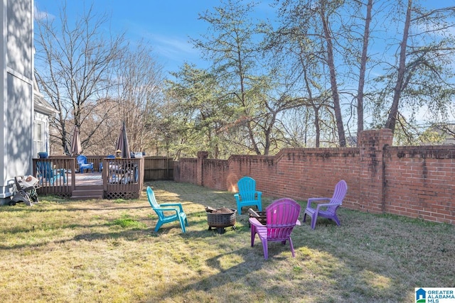 view of yard with a deck and an outdoor fire pit