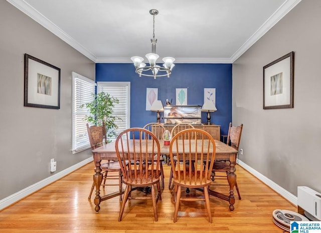 dining area featuring an inviting chandelier, ornamental molding, and light wood-type flooring