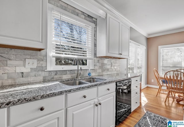 kitchen with sink, light hardwood / wood-style flooring, dishwasher, ornamental molding, and white cabinets