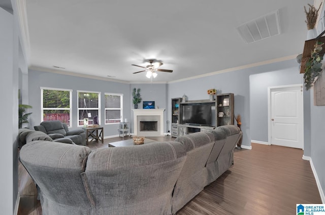 living room with crown molding, dark wood-type flooring, and ceiling fan