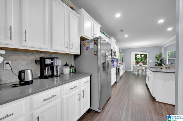 kitchen featuring sink, white cabinetry, stainless steel appliances, dark hardwood / wood-style floors, and decorative backsplash