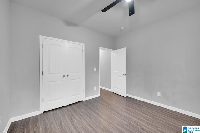 unfurnished bedroom featuring hardwood / wood-style flooring, ceiling fan, and a closet