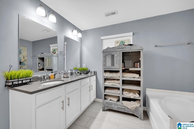 bathroom with tile patterned floors, vanity, and a bathing tub