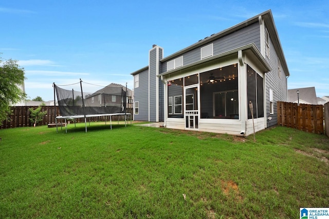 rear view of house featuring a sunroom and a lawn