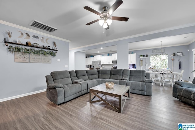 living room featuring ceiling fan, ornamental molding, and wood-type flooring