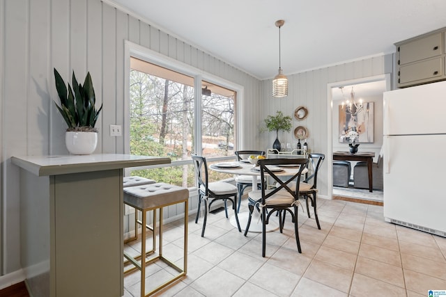 dining room featuring light tile patterned floors and ornamental molding