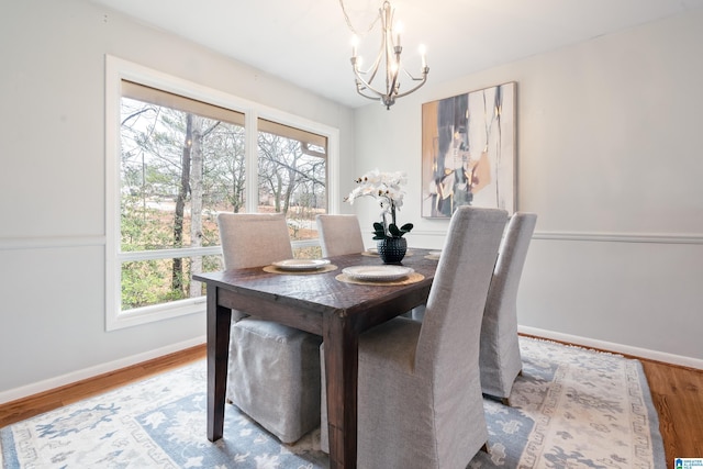 dining space with light hardwood / wood-style floors and a chandelier