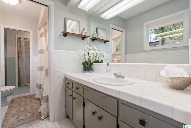 bathroom with tile patterned flooring, vanity, tile walls, and toilet