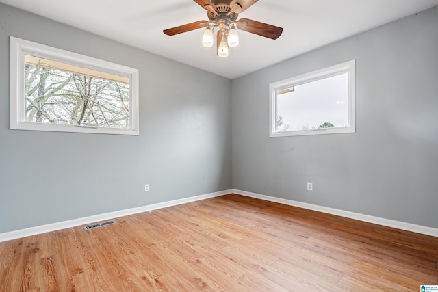 empty room with ceiling fan and light hardwood / wood-style flooring