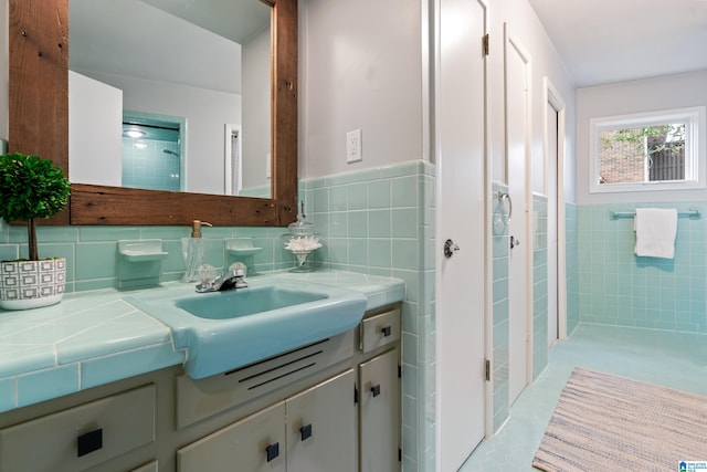 bathroom featuring vanity and tile walls