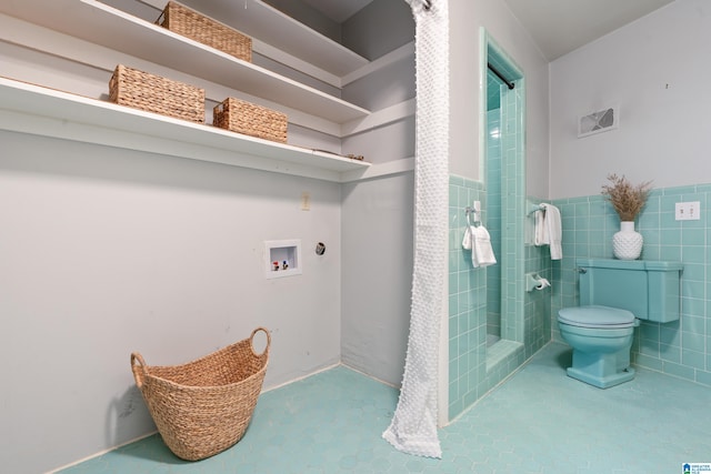 bathroom with tile walls, tile patterned floors, and toilet