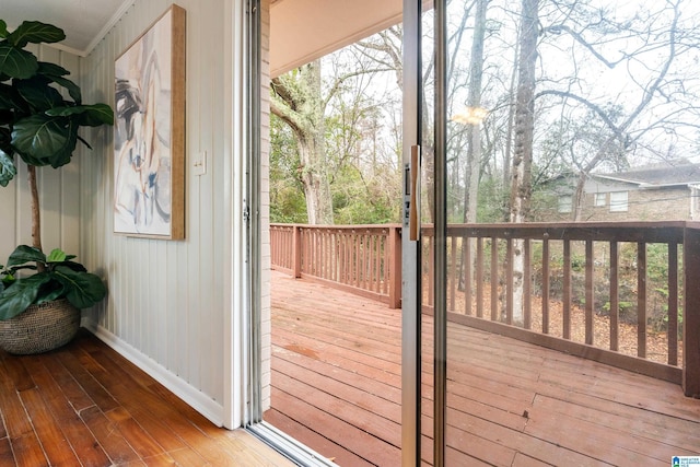 doorway with crown molding and wood-type flooring