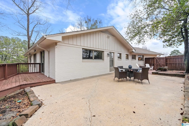 rear view of house with a wooden deck and a patio area