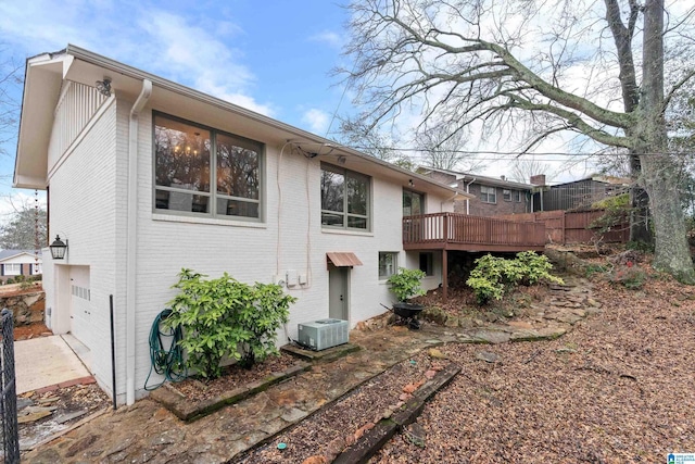 view of property exterior with a garage and a deck