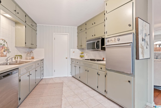 kitchen with sink, backsplash, stainless steel appliances, and light tile patterned floors