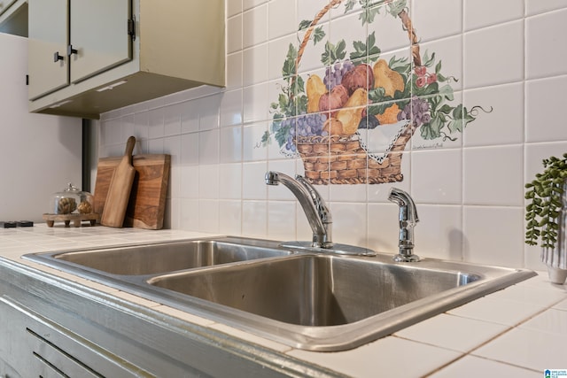 interior details featuring sink, tile countertops, and backsplash