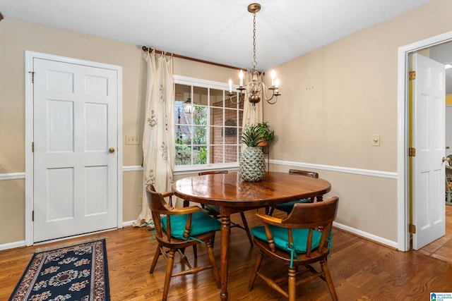 dining space with wood-type flooring and a notable chandelier