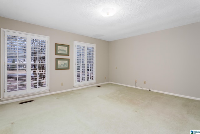 carpeted spare room with a textured ceiling