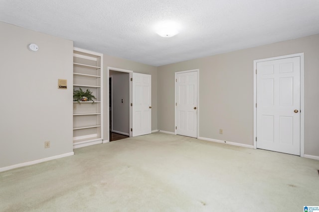 unfurnished bedroom with light carpet and a textured ceiling