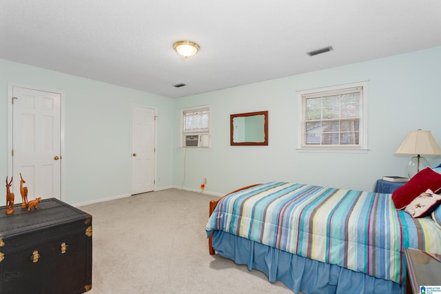 carpeted bedroom featuring multiple windows, cooling unit, and a textured ceiling