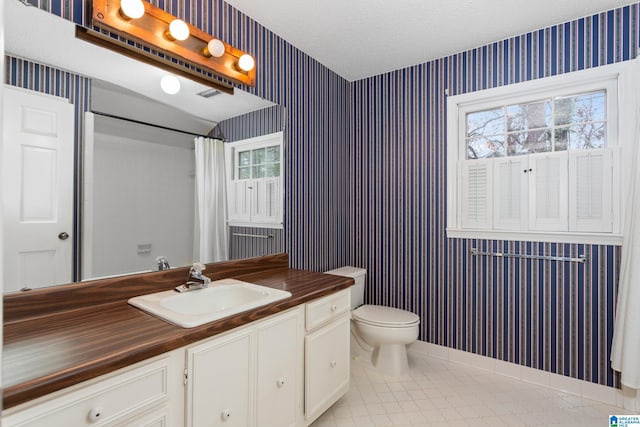 bathroom with vanity, toilet, a shower with shower curtain, and a textured ceiling