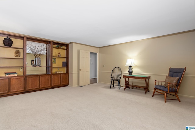 living area featuring crown molding and light colored carpet