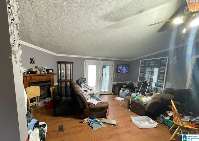 interior space with french doors, lofted ceiling, crown molding, a textured ceiling, and hardwood / wood-style floors