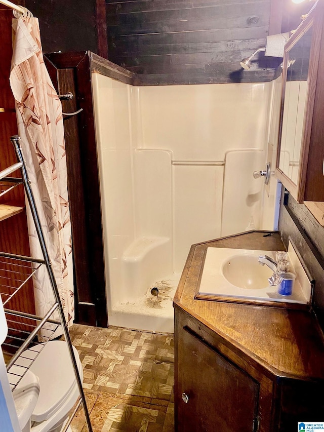 bathroom featuring parquet flooring, vanity, toilet, and a shower with shower curtain