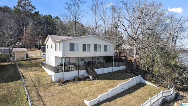 back of house featuring a wooden deck and a yard